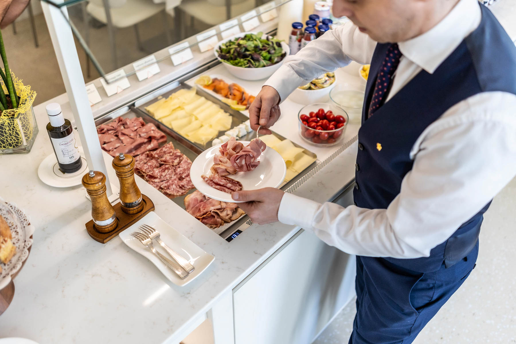 Uomo che serve cibo da un buffet al Grand Hotel Duchi d'Aosta